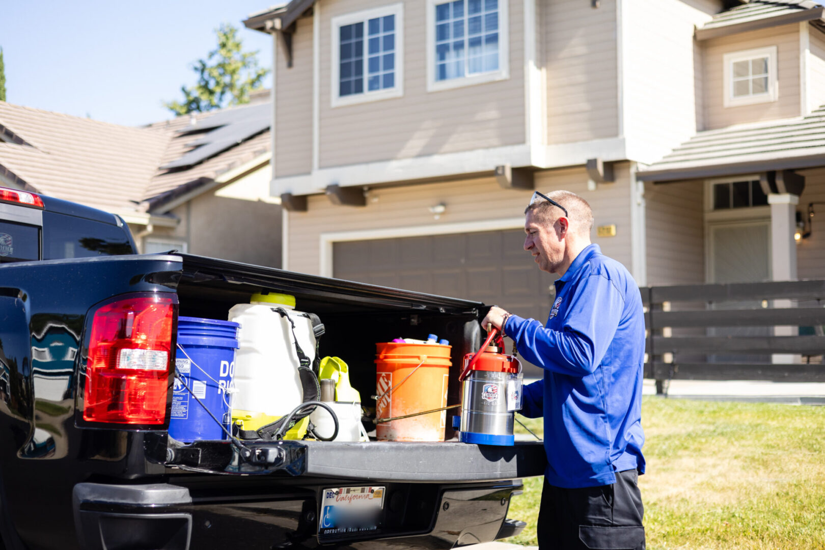 A man standing next to a truck with a large amount of stuff in the back.